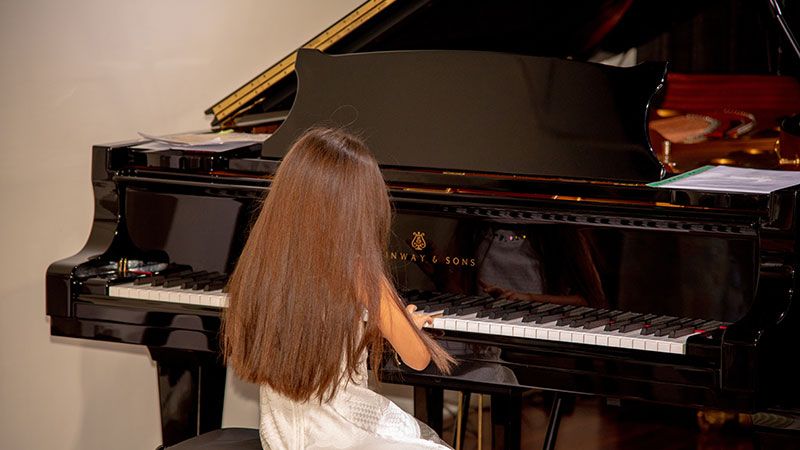 Young girl playing on a Steinway