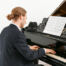 Man playing grand piano in concert-feat