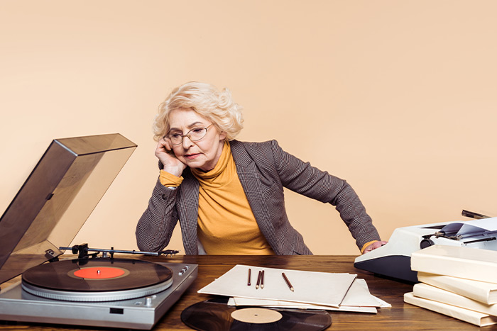 Old lady thinking and music records and papers are on the table