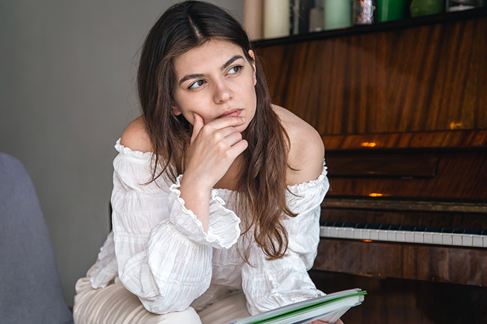 Woman pianist with a book thinking