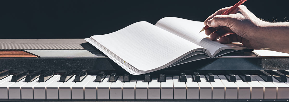 Notebook on a digital piano representing focused piano practice and identifying key improvement areas