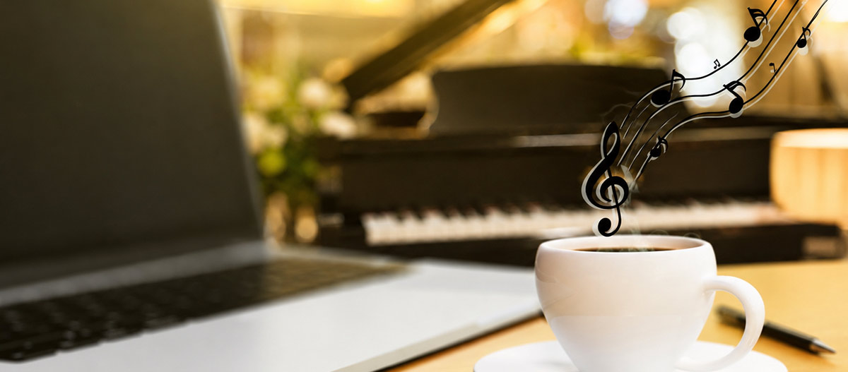 Laptop, coffee and piano representing music as a rewarding escape from professional life