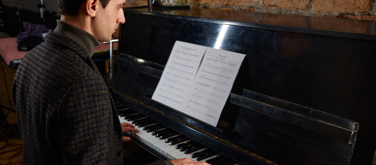 Professional man concentrating while playing piano after work