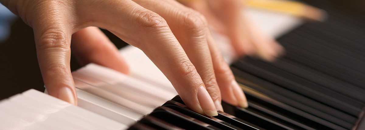Close up of a pianist's fingers pressing piano keys